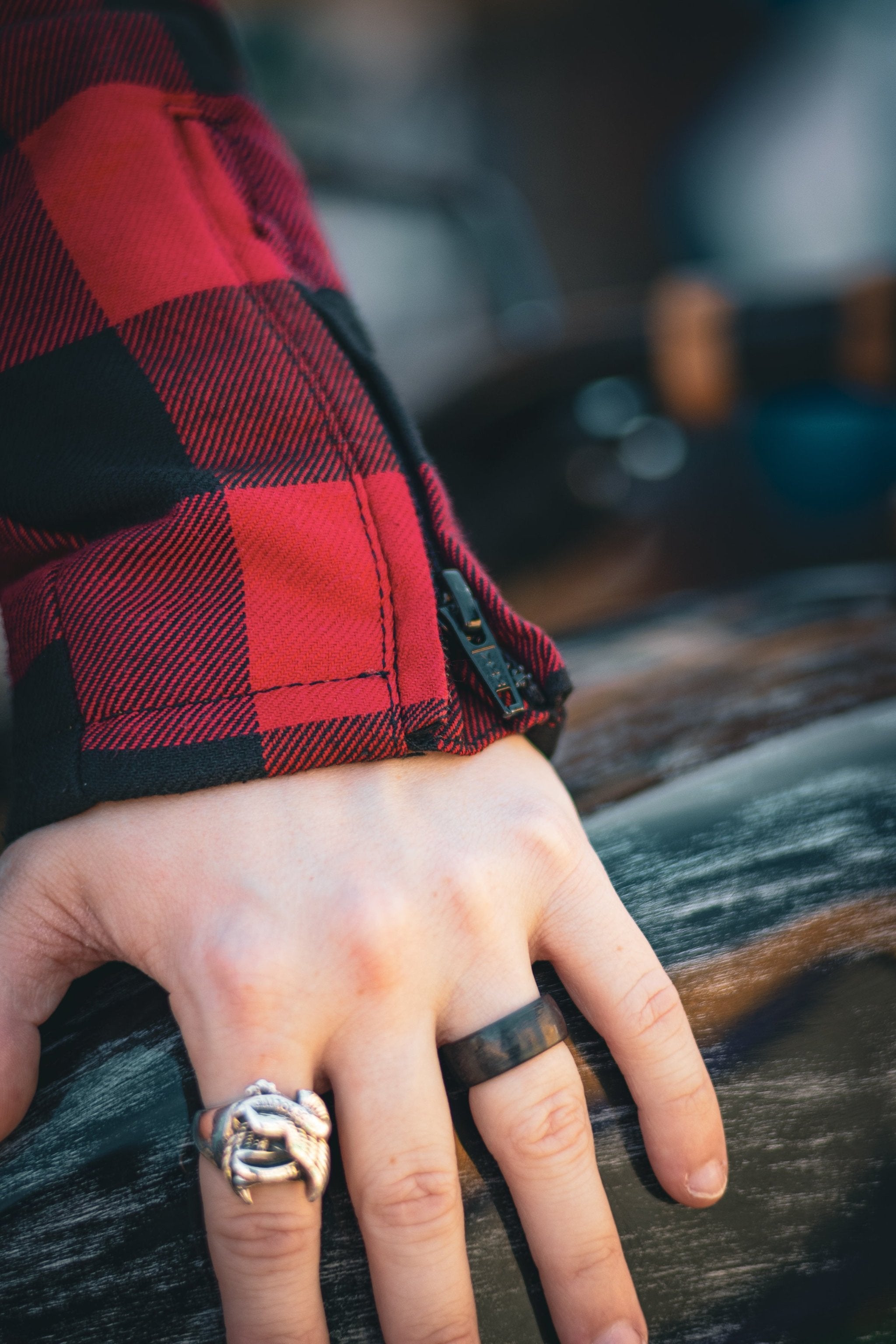 close up of sleeve with zipper detail on red and black flannel-style women's jacket from moto girl