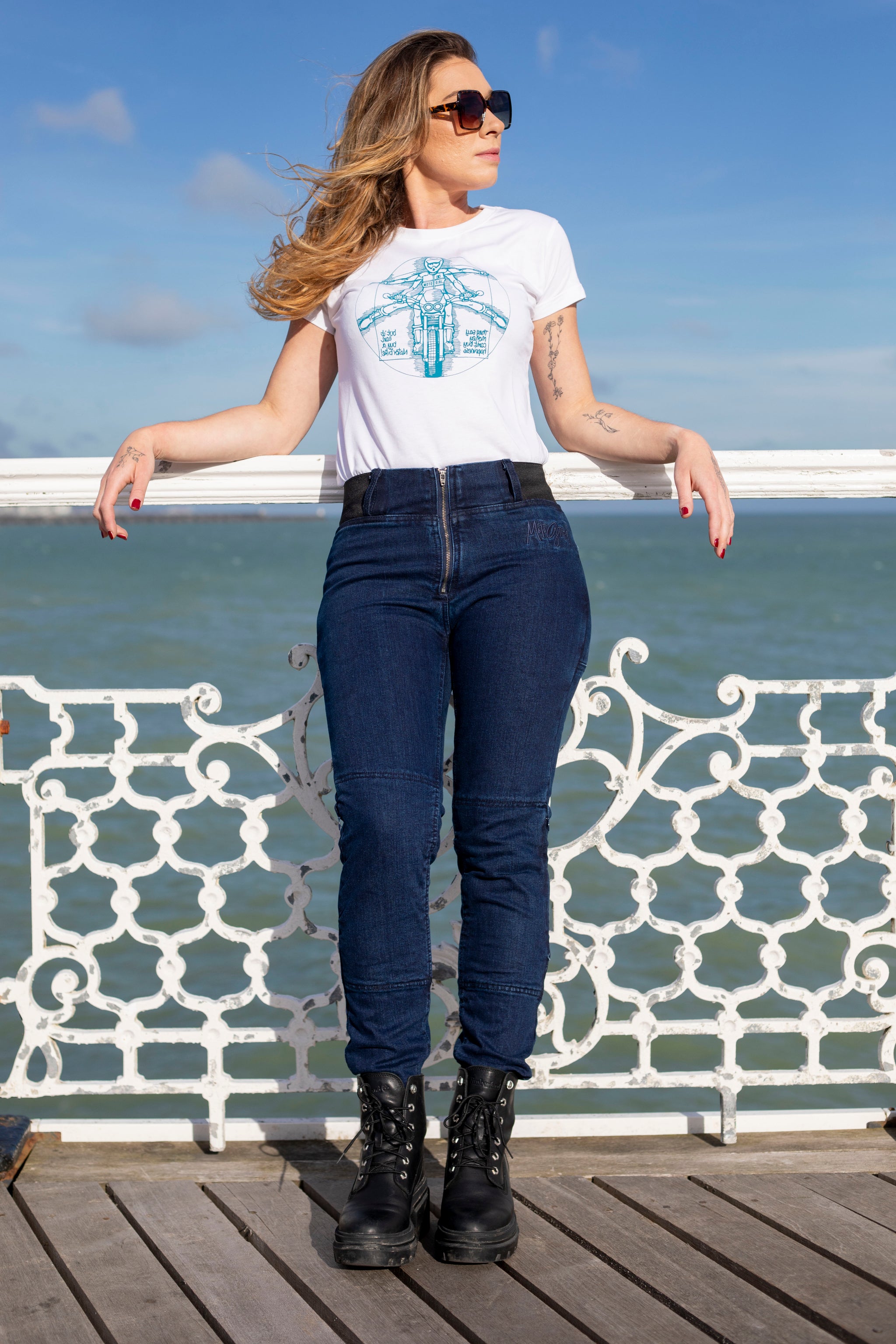 young woman wearing white t-shirt and blue jeans leaning on the bridge