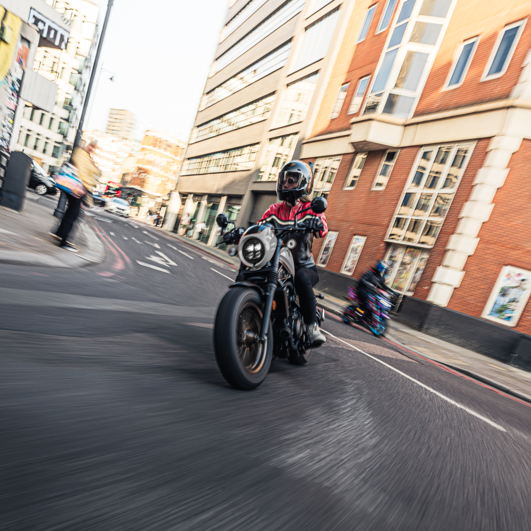 woman motorcyclists in black red leather jacket on her bike riding in London