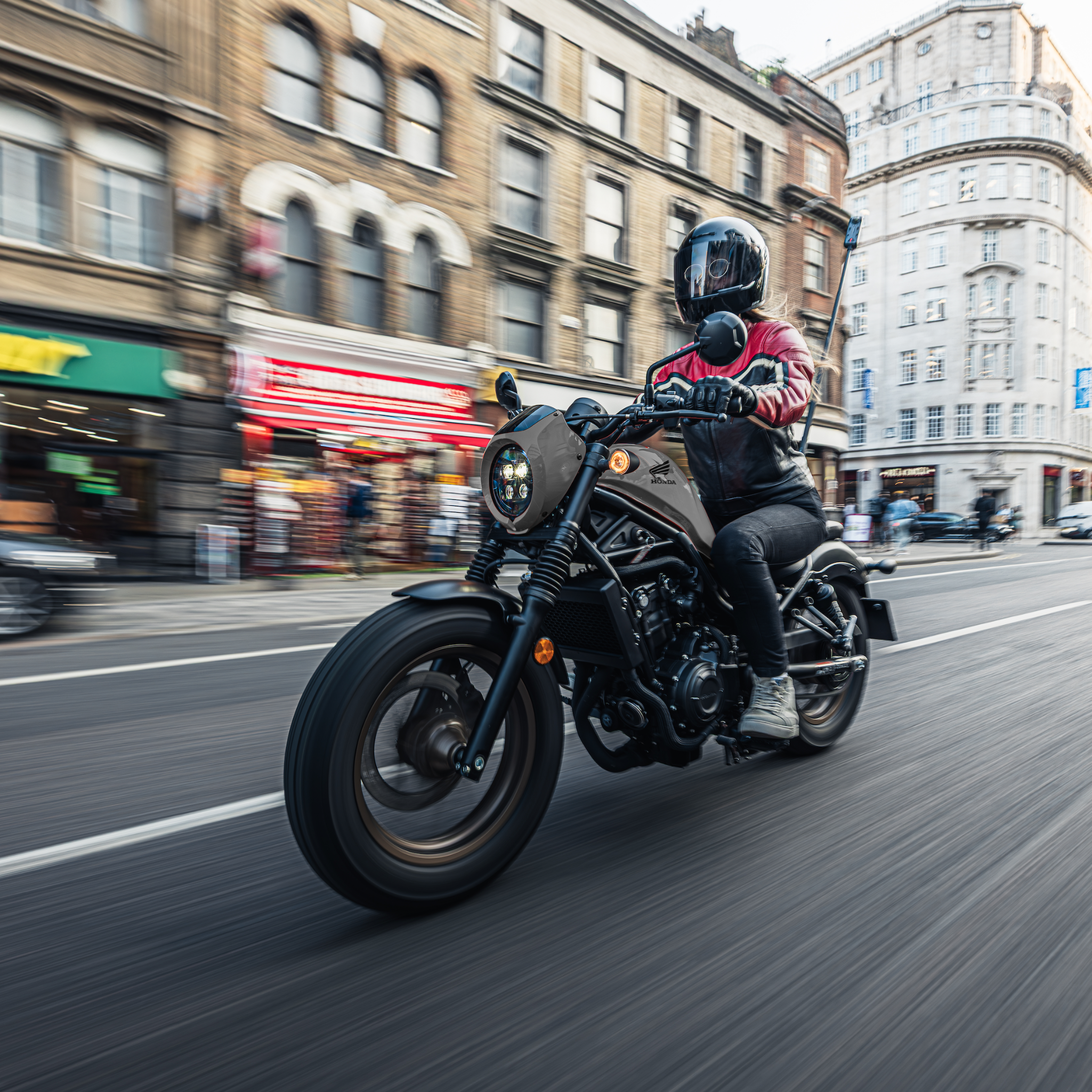 woman motorcyclists in black red leather jacket on her bike riding in London