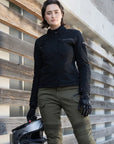 a woman wearing black shirt looking lady motorcycle jacket with front pockets and zippers and green pants