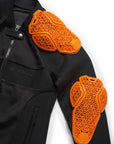 Black jacket with orange protective shoulder pads on a white background