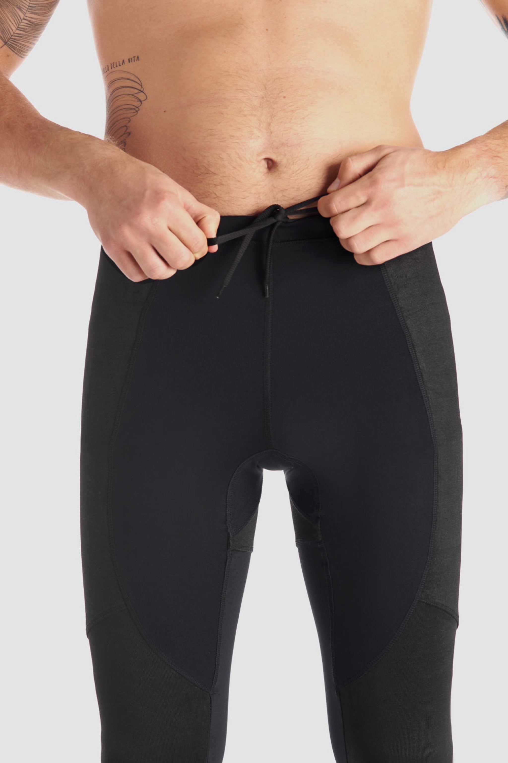 a man tying his black base layer leggings