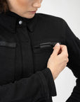 a woman zipping front pocket on her Black shirt looking lady motorcycle jacket with front pockets and zippers