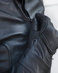 Women closing motorcycle jacket's zipper wearing black leather Shima motorcycle gloves