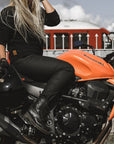 A blond woman on a motorcycle wearing women's black motorcycle jeans Lorica Kevlar from Pando Moto