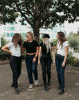 Four smiling women wearing black and blue women’s motorcycle jeans from Moto Girl.