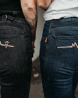 The backs of two women wearing women's motorcycle jeans from Moto Girl with heartbeat detail.