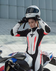 A woman putting her helmet on and wearing Women's racing suit MIURA RS in black, white and fluo from Shima
