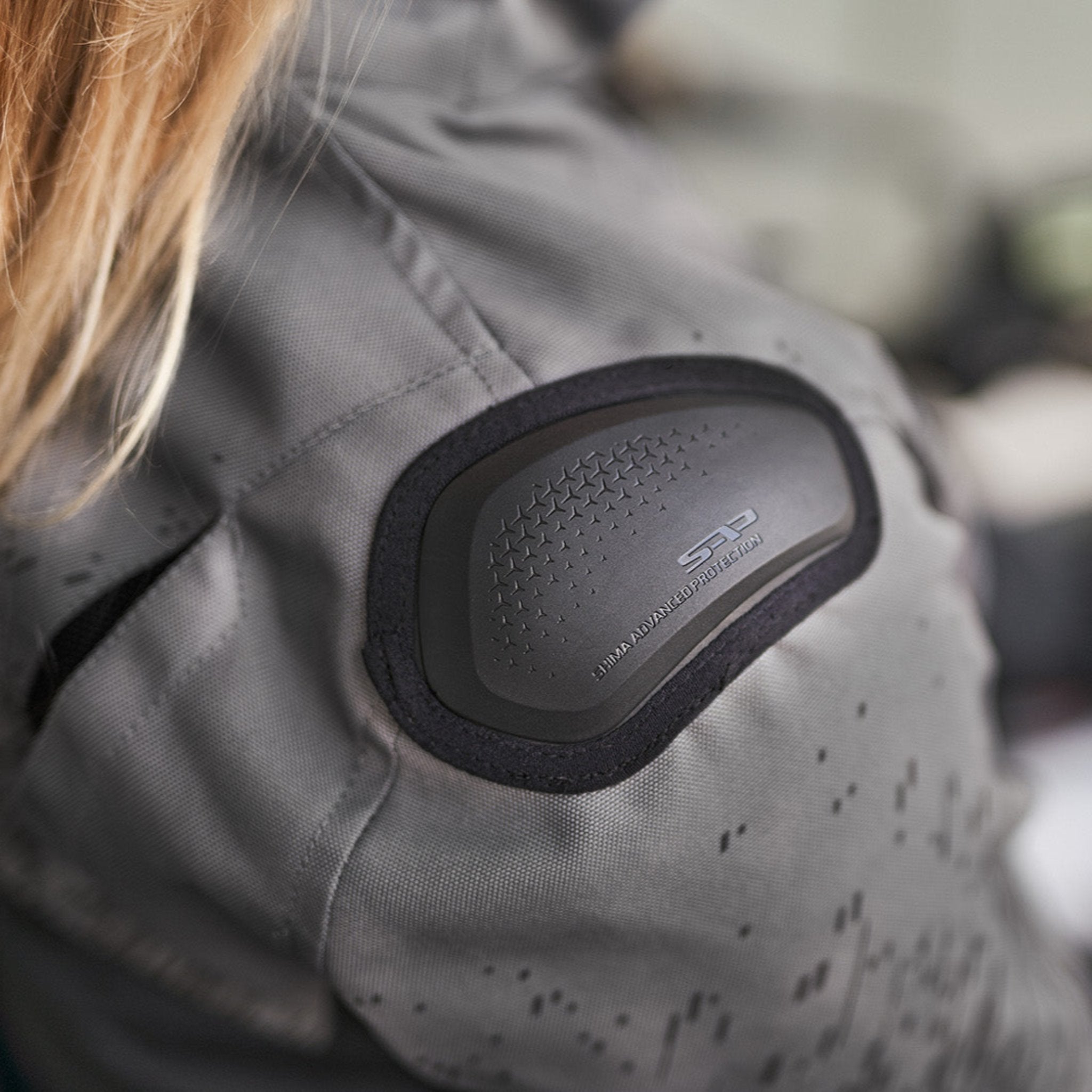 a slider on the shoulder of grey women's motorcycle jacket from SHIMA
