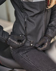 Woman's hand zipping the pocket on grey women's motorcycle jacket from SHIMA