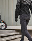 a woman walkig towards her motorcycle wearing grey women's motorcycle jacket from SHIMA