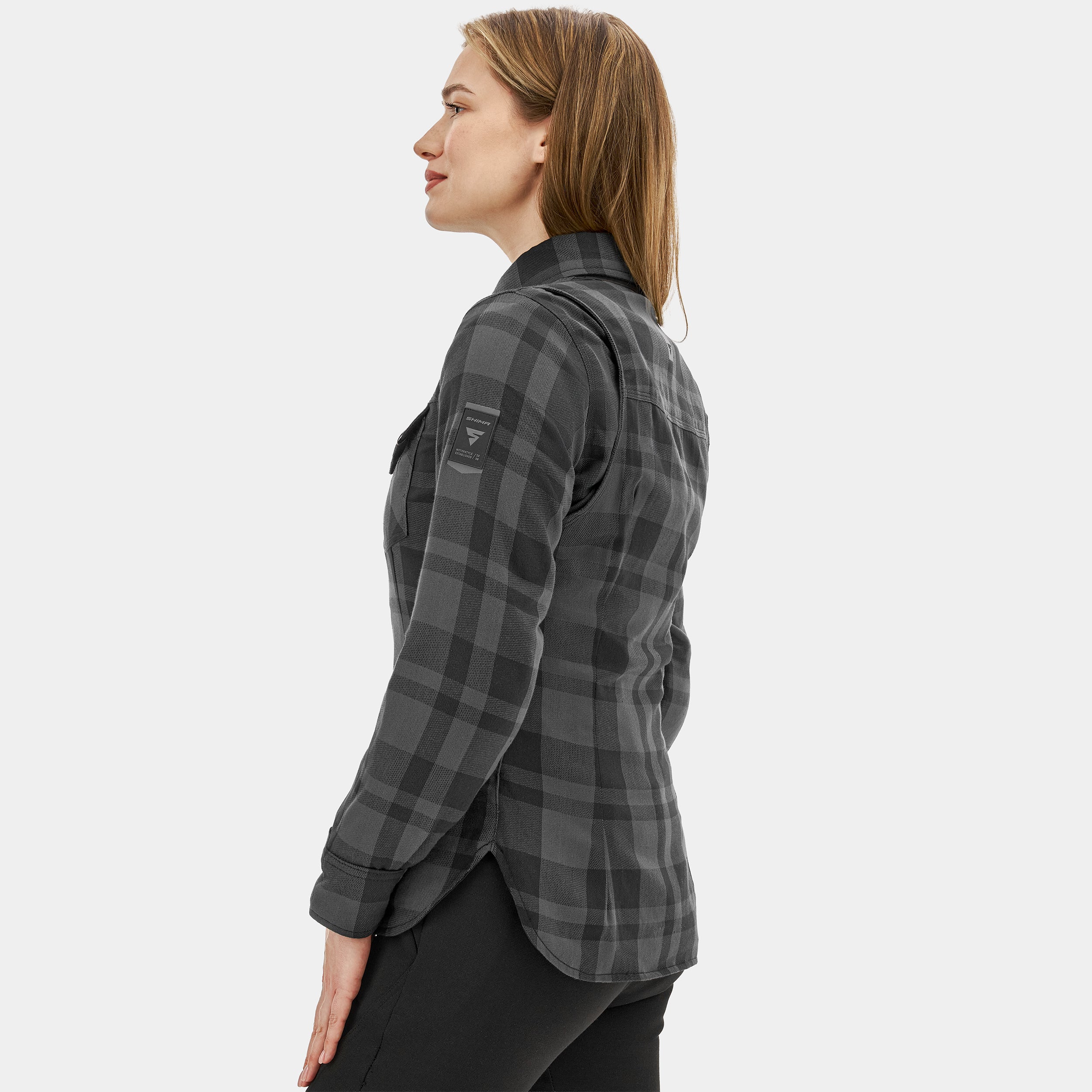 Woman wearing a gray plaid shirt on a white background