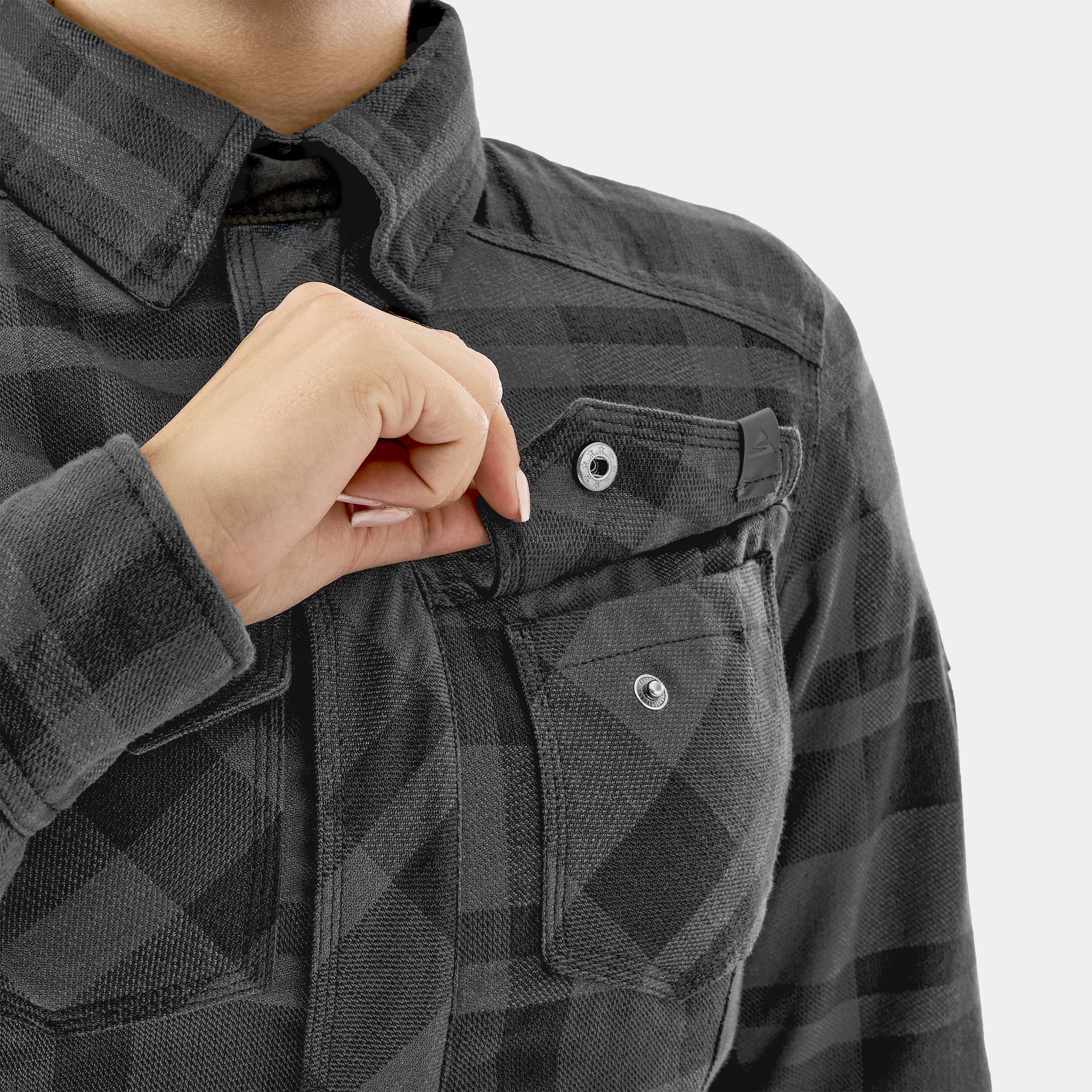 Person wearing a black checkered jacket with a close-up of a pocket.