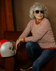 an older lady wearing a knitted red and white jumper with chessboard motives from Wildust