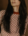 a young woman wearing a knitted red and white jumper with chessboard motives from Wildust