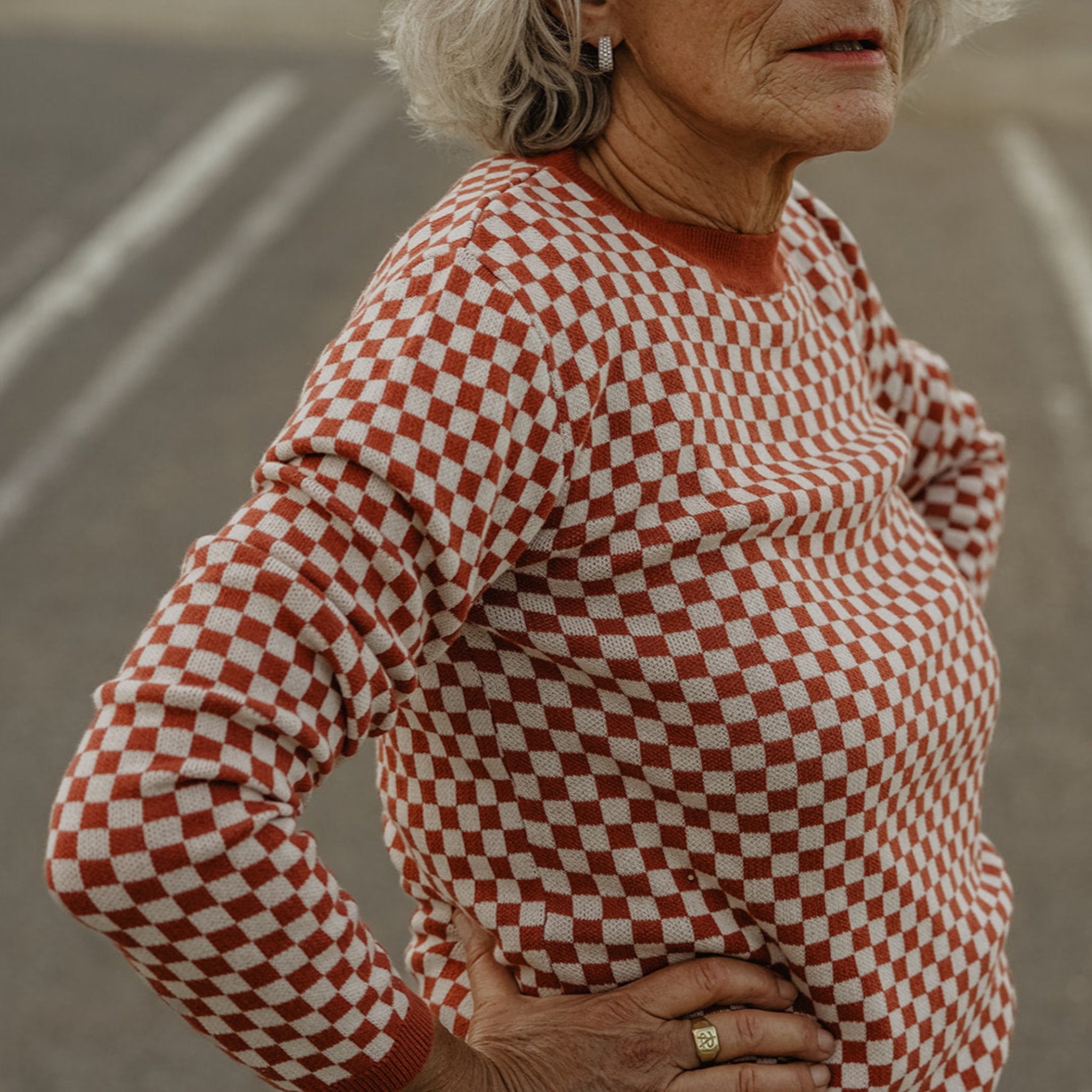 an older lady wearing a knitted red and white jumper with chessboard motives from Wildust