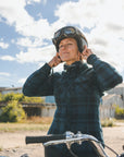 A woman putting on her motorcycle helmet
