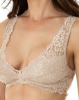 Dark-haired woman wearing nude-colored wide shoulder lace bralette from Tramonte.