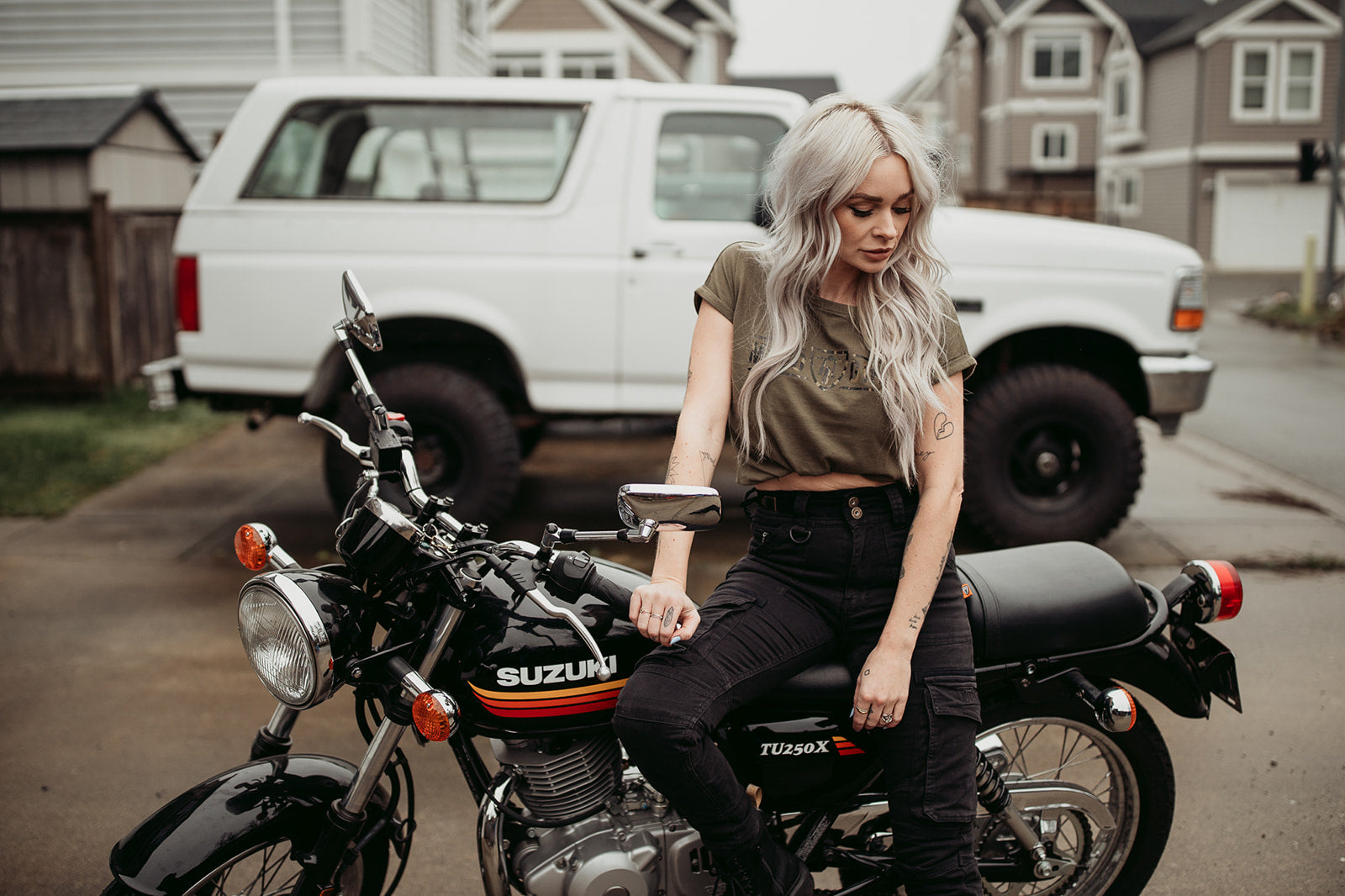 A woman siting on a motorcycle wearing black cargo pants Lara from Moto Girl