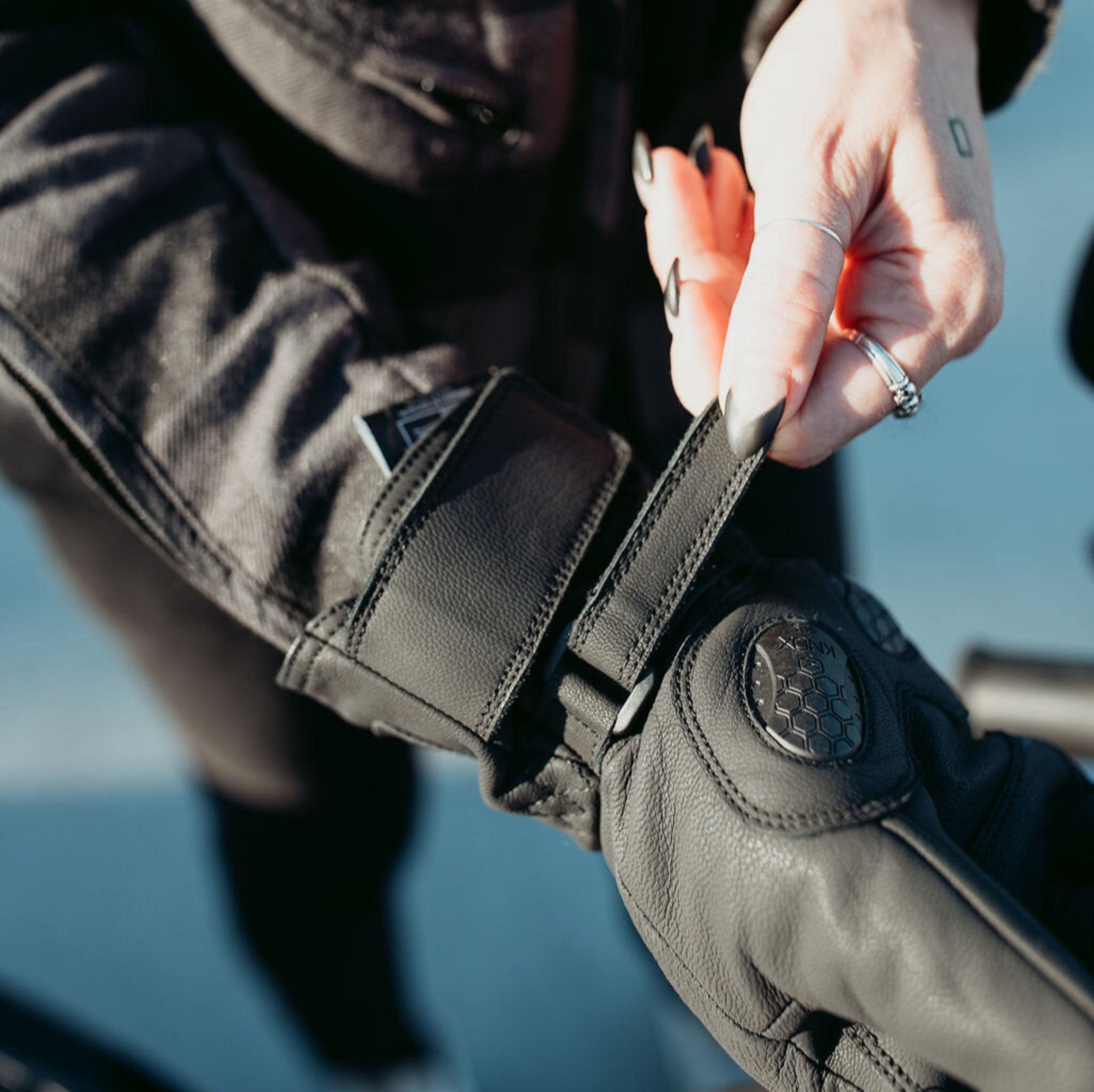 Woman wearing the Nandi gloves from Motogirl while adjusting the velcro closure on the wrist.