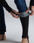 man's hands rolling up the jeans and wearing base layer leggings underneath 