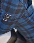 Person wearing a blue plaid shirt with a SHIMA motorcycle wear brand logo on the sleeve