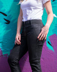 a close up of woman's legs wearing black moto jeans 