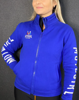 a blond woman wearing Motogirl clothing blue sweatshirt with a front zip