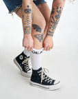 Women's tattood legs wearing white socks with  "gear" motive