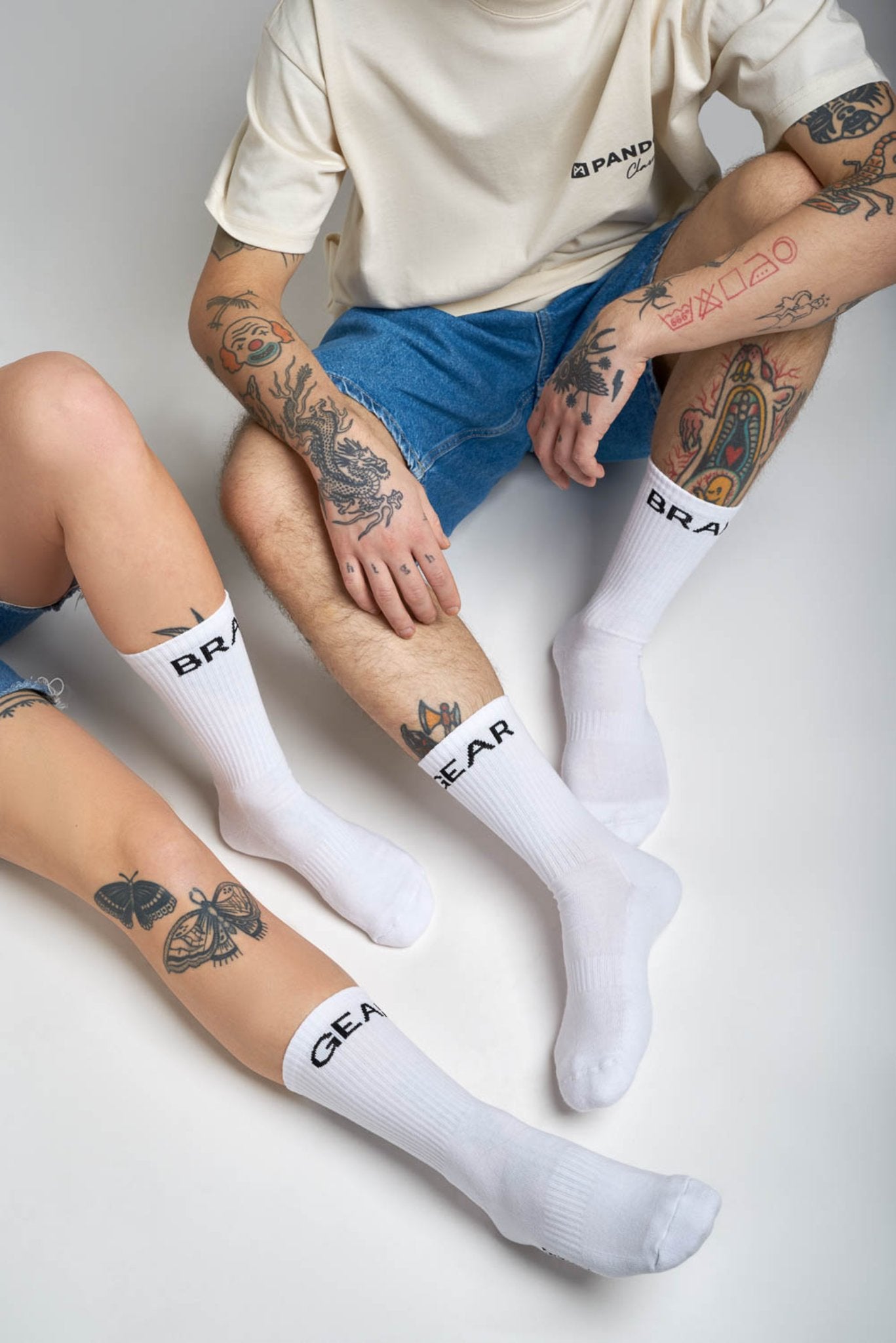 man and women tattood legs wearing white socks  with &quot;break&quot; and &quot;gear&quot;