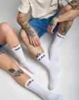 man and women tattood legs wearing white socks  with "break" and "gear"