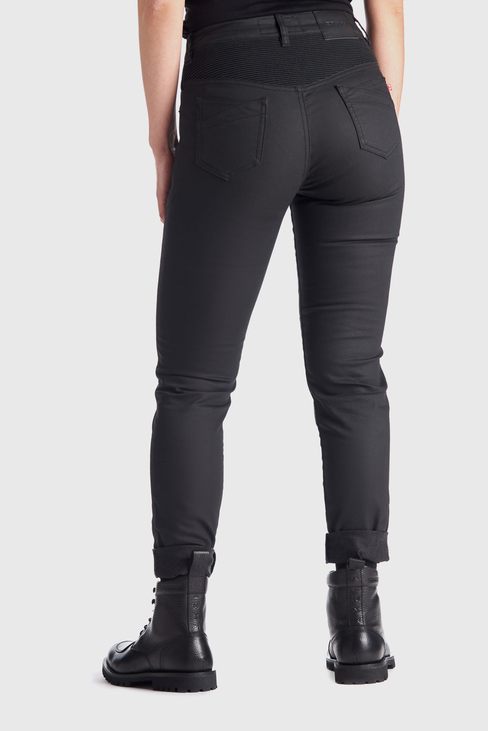 The back of woman&#39;s legs wearing slim-fit motorcycle jeans from Pando Moto 