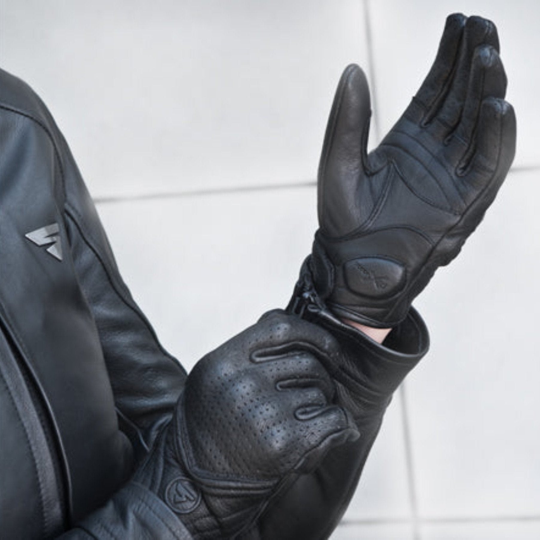 A woman putting on black female motorcycle gloves from Shima 