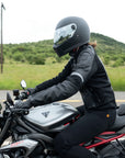A woman driving a motorcycle wearing Black leather women's motorcycle jacket with reflectors from Moto Girl 