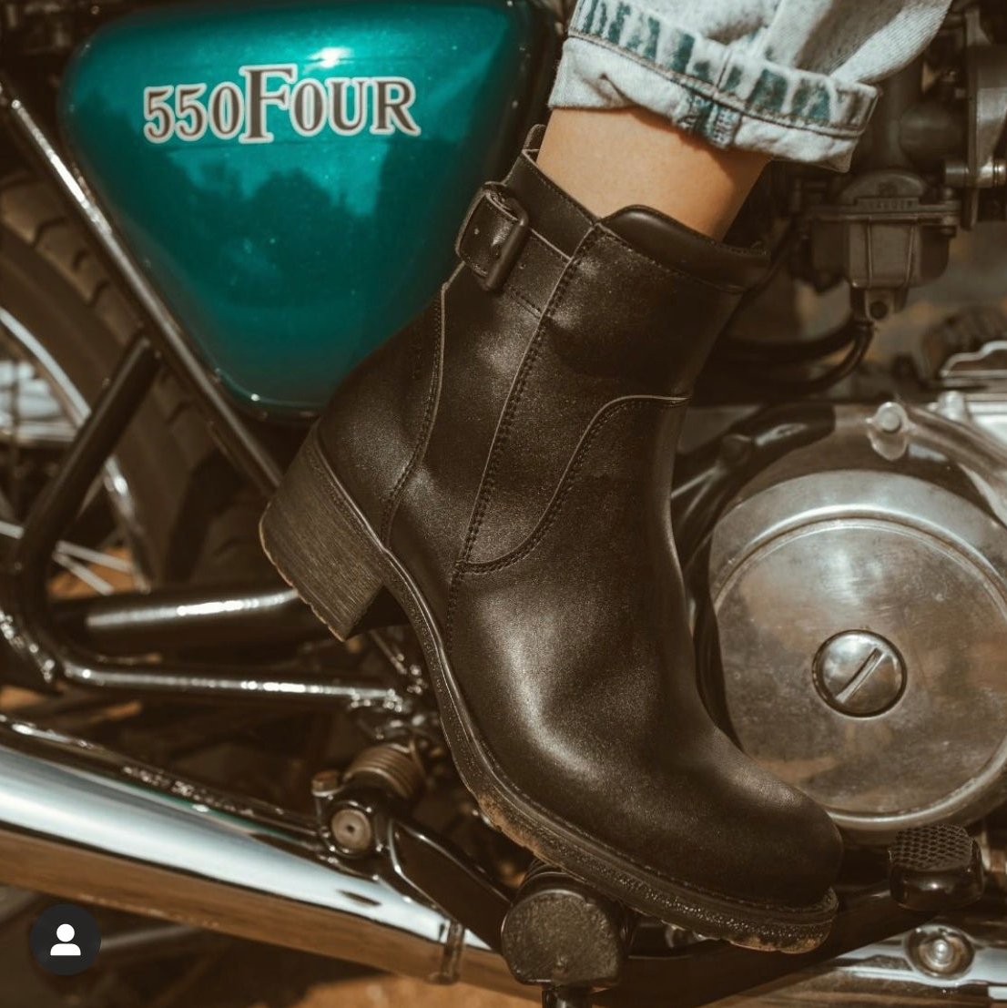 Close up of a woman&#39;s foot on the motorcycle break wearing women&#39;s black leather motorcycle shoes 