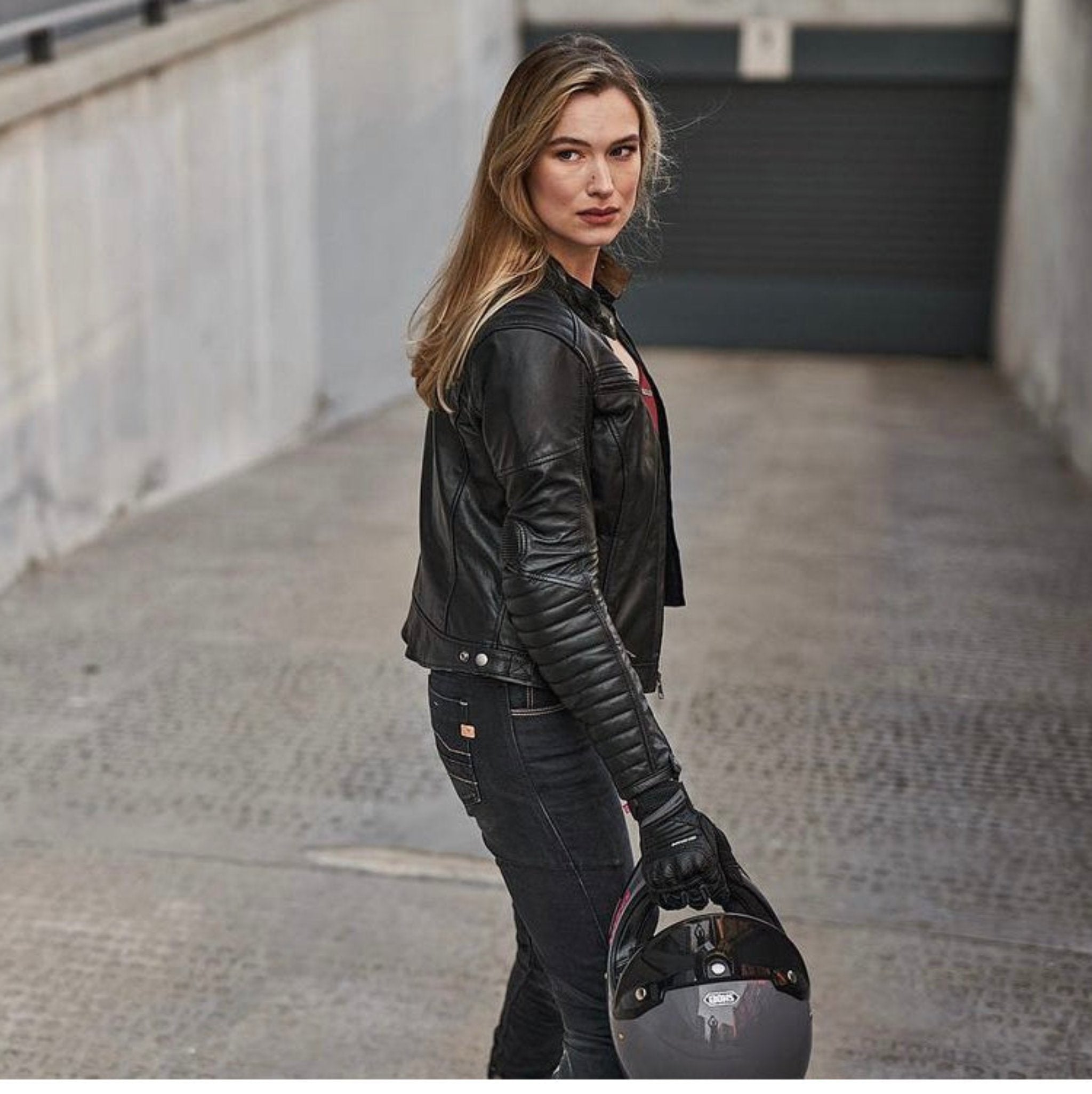 A blond woman wearing Black leather motorcycle jacket for women from Shima