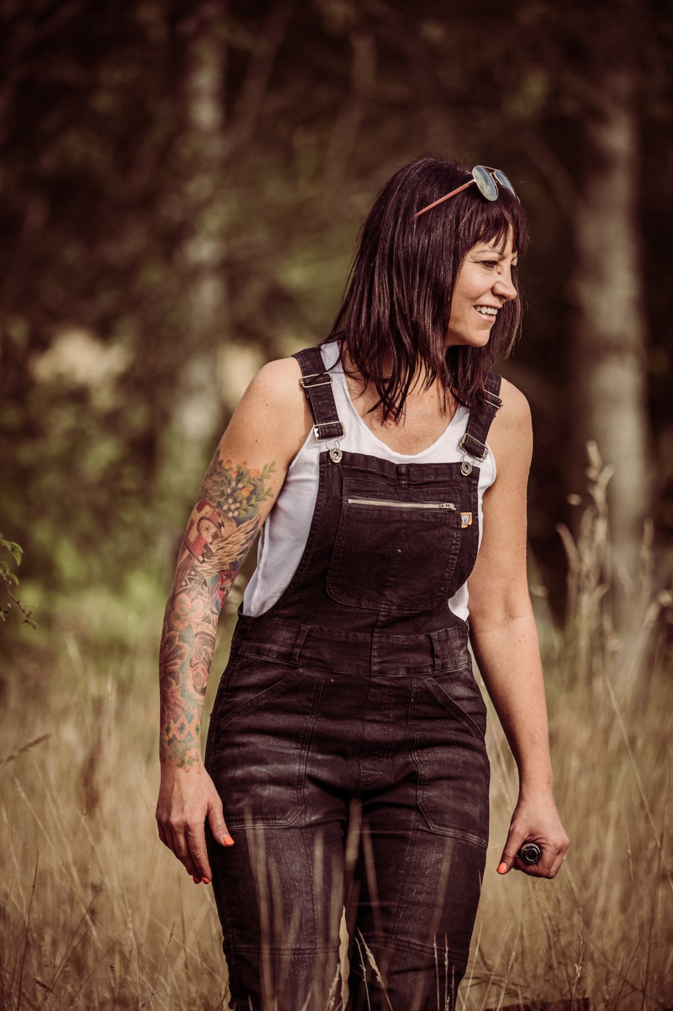 A woman in the field wearing black motorcycle overall from Moto Girl