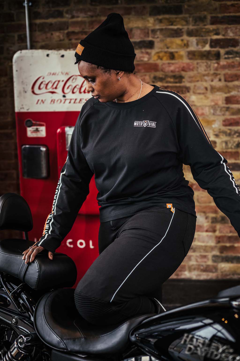 A woman with black motorcycle wearing black MotoGirl leggings and sweatshirt