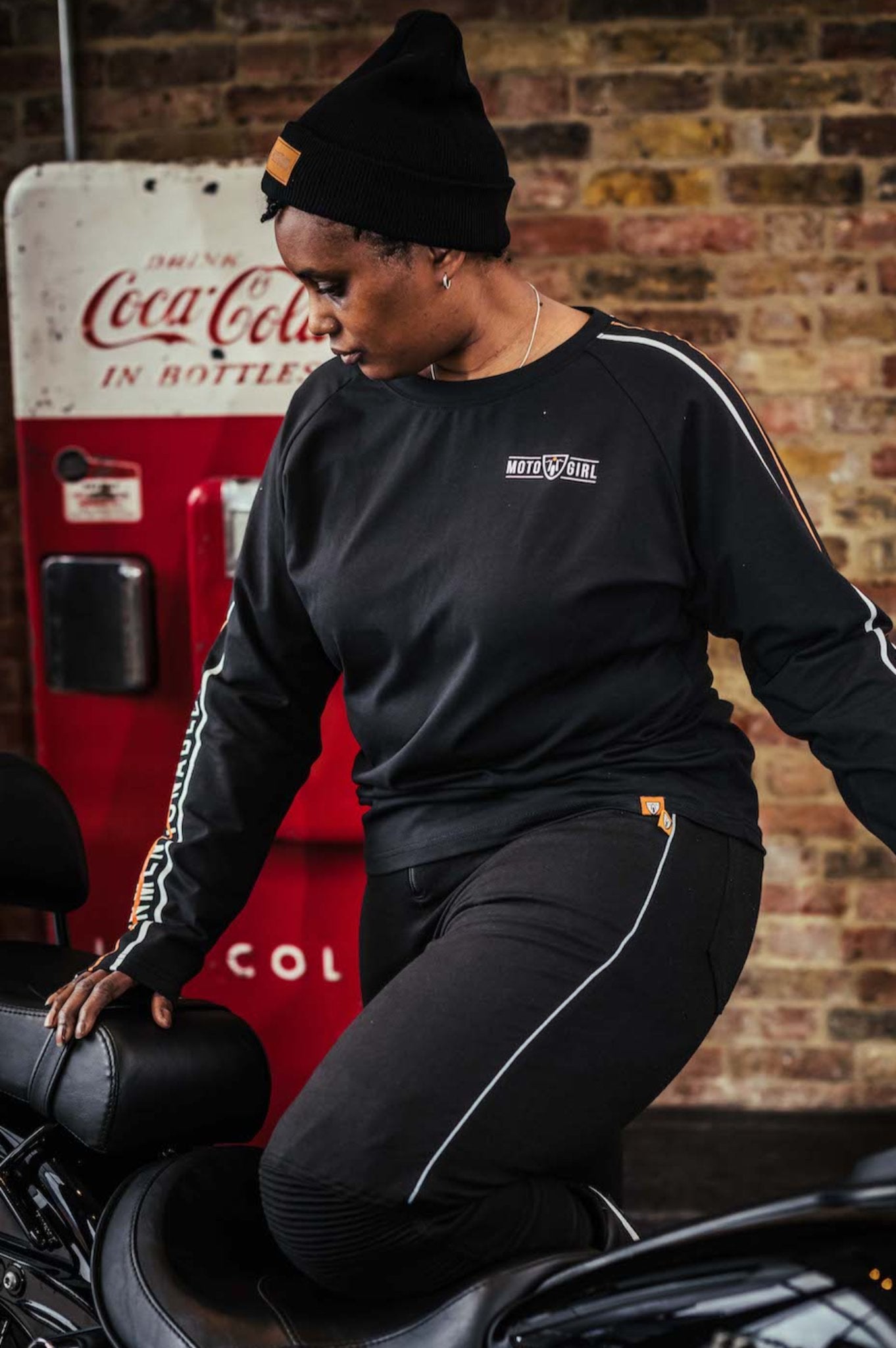 A woman with black motorcycle wearing black MotoGirl leggings and sweatshirt