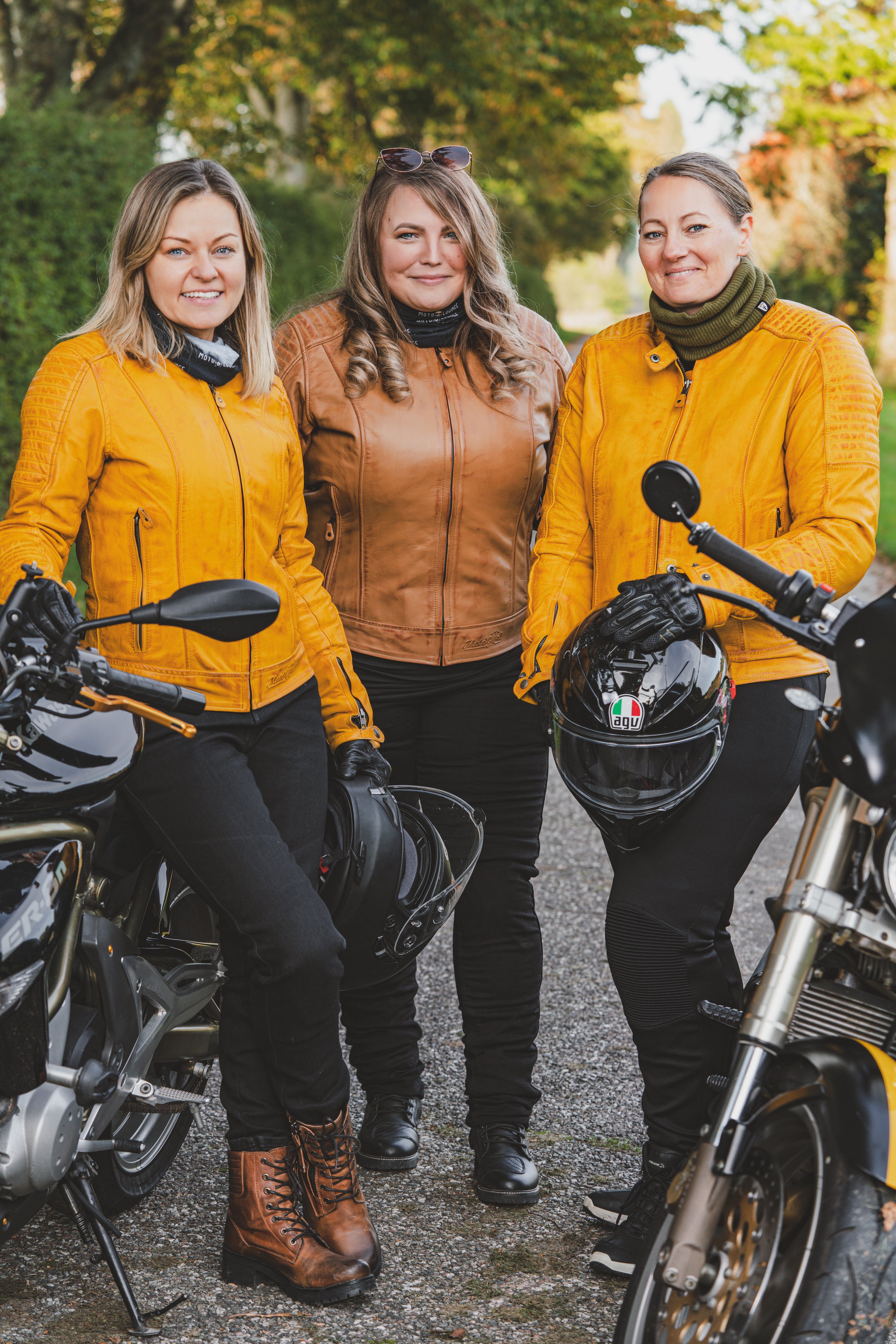 Three women with motorcycles wearing colourful motorcycle jackets from Moto Girl 