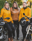 Three women with motorcycles wearing colourful motorcycle jackets from Moto Girl 