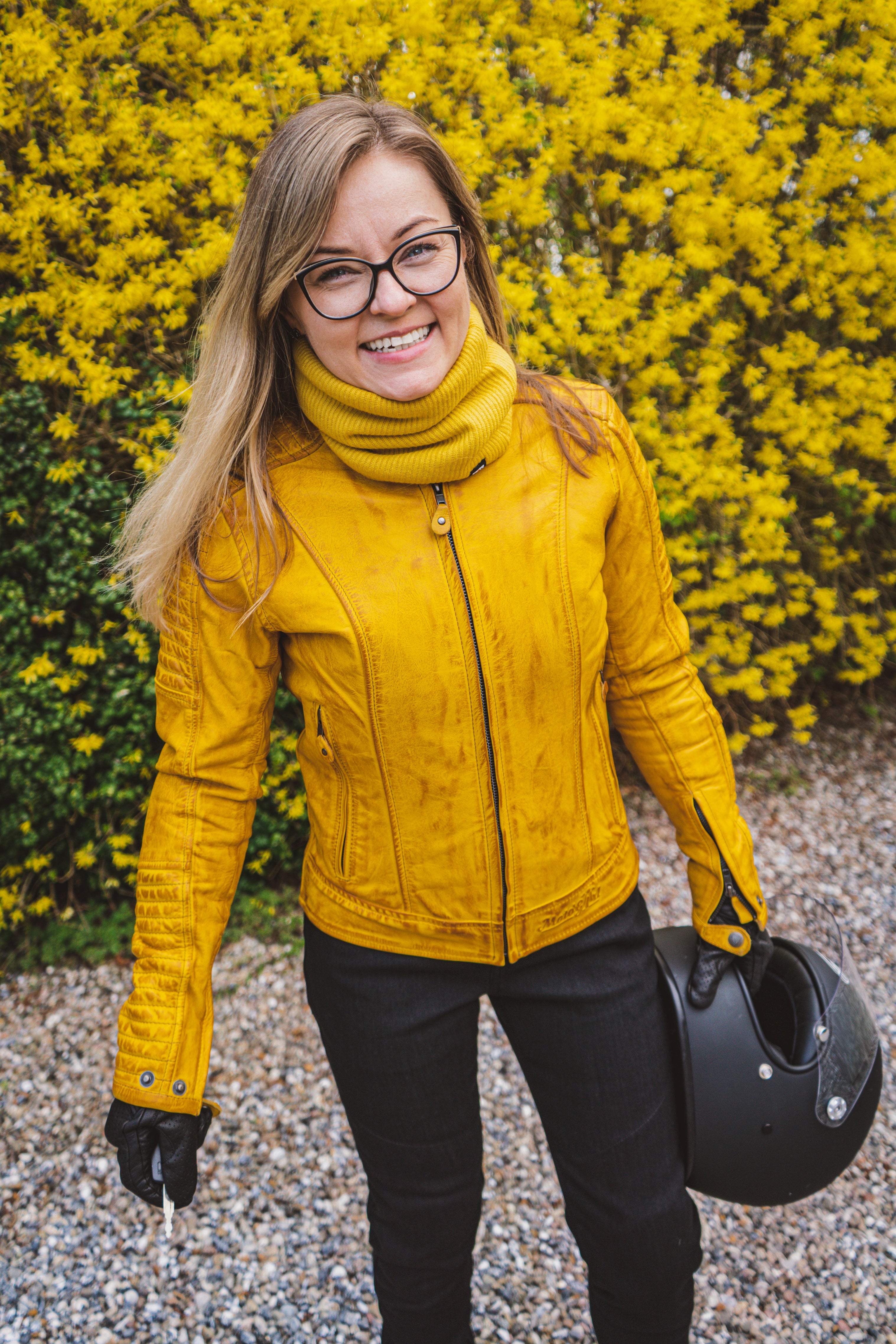 A smiling woman wearing yellow women&#39;s motorcycle leather jacket 