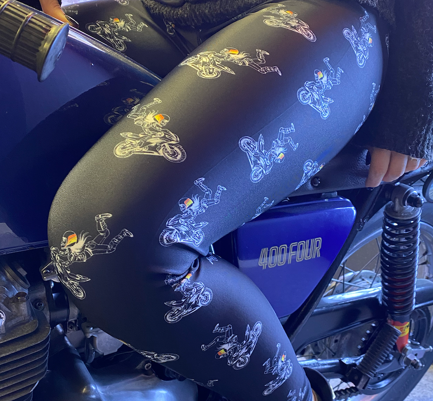 A close up of a woman's leg wearing leggings with motorcycle motives