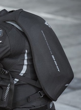 A person's back wearing black motorcycle backpack 