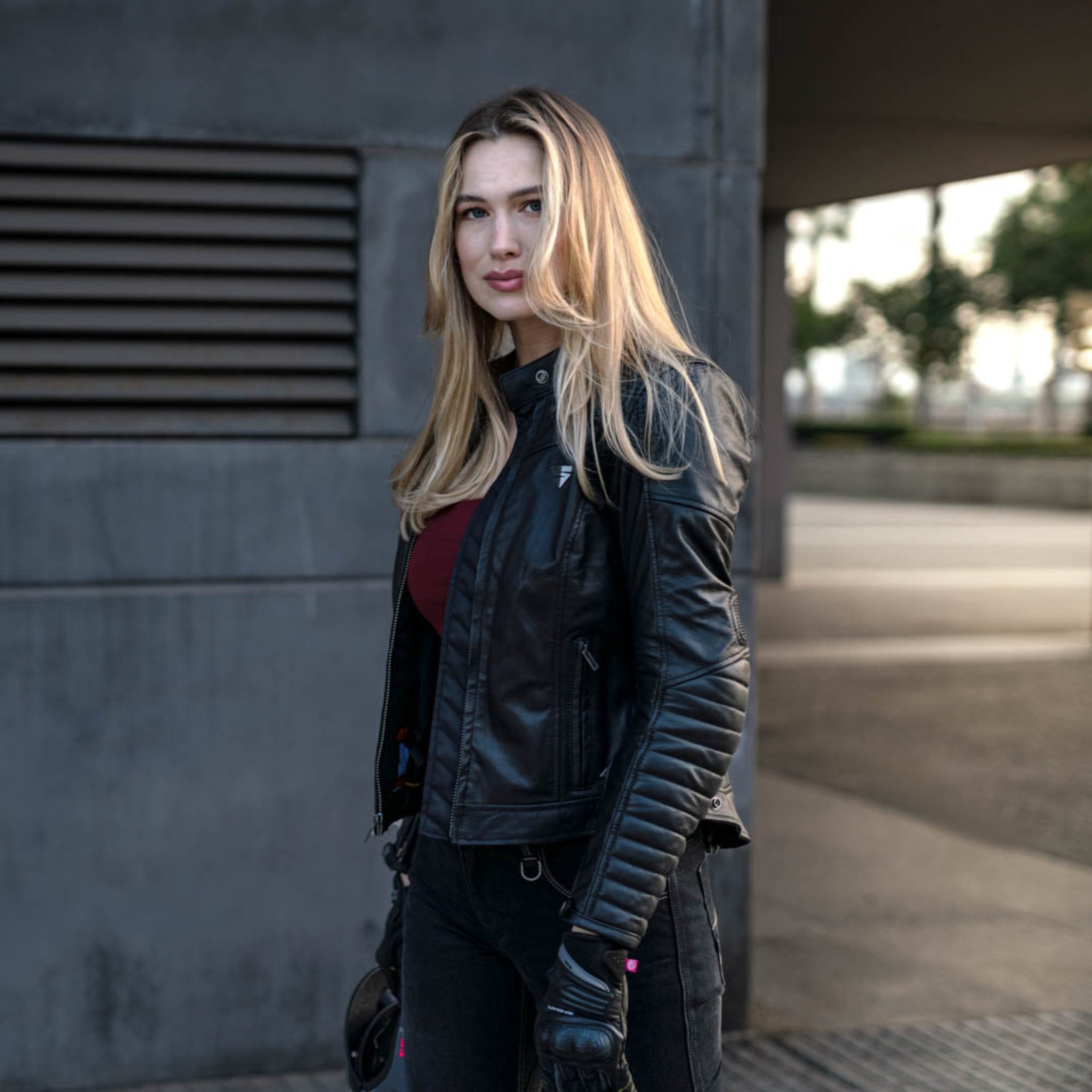 A blond woman wearing Black leather motorcycle jacket for women from Shima