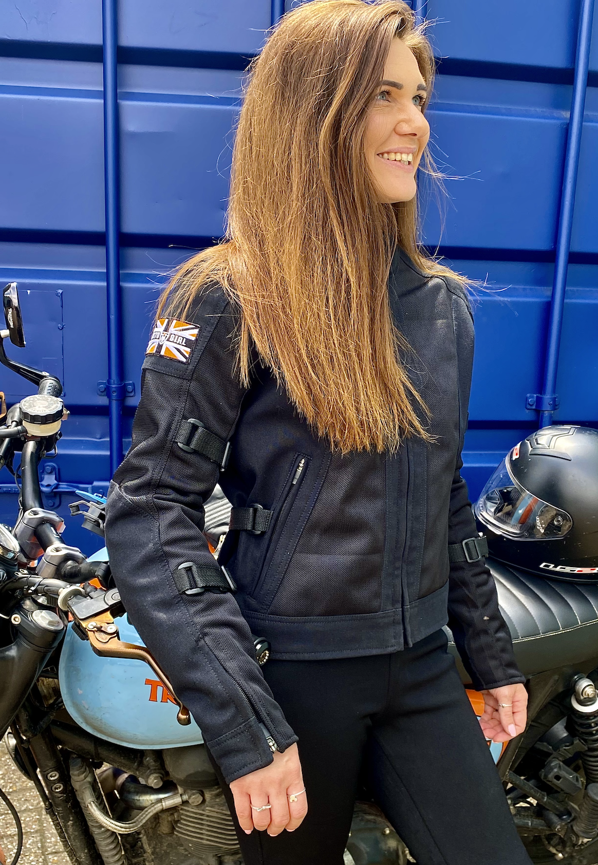 A smiling woman wearing Black summer mesh women's motorcycle jacket with Motogirl patch