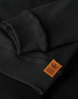 The close up of the brown patch Rugged Design on the black sweatshirt from Pando Moto 
