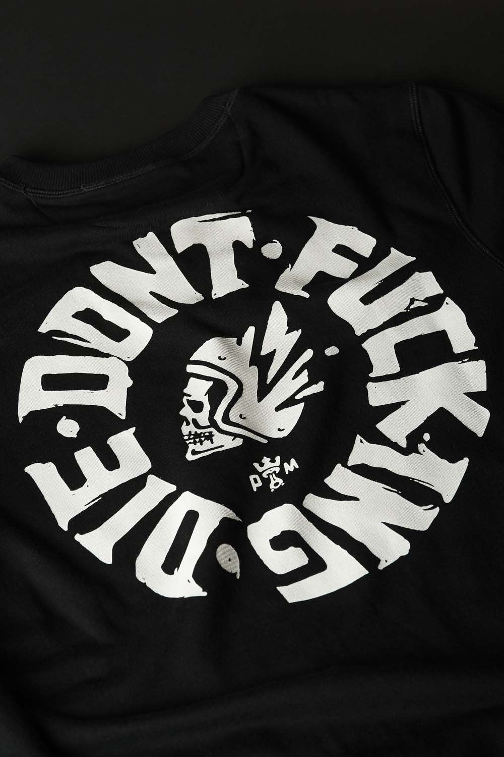 A close up of the Don't fucking die motive on the black Pando Moto motorcycle sweatshirt 
