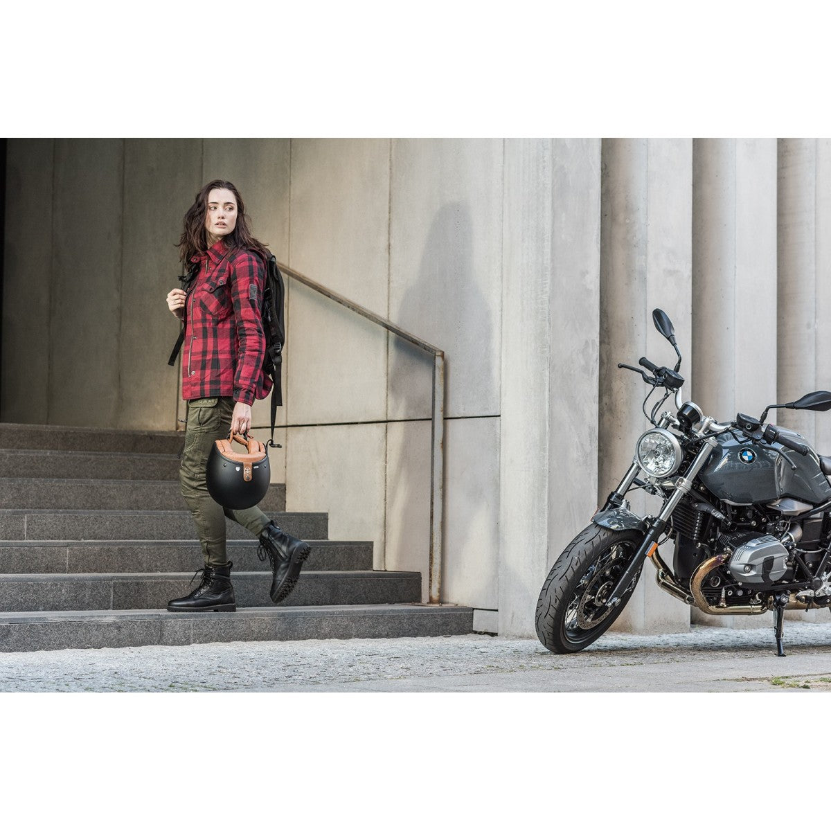 A women walking away from her motorcycle and wearing Thomason black motorcycle boots from Shima
